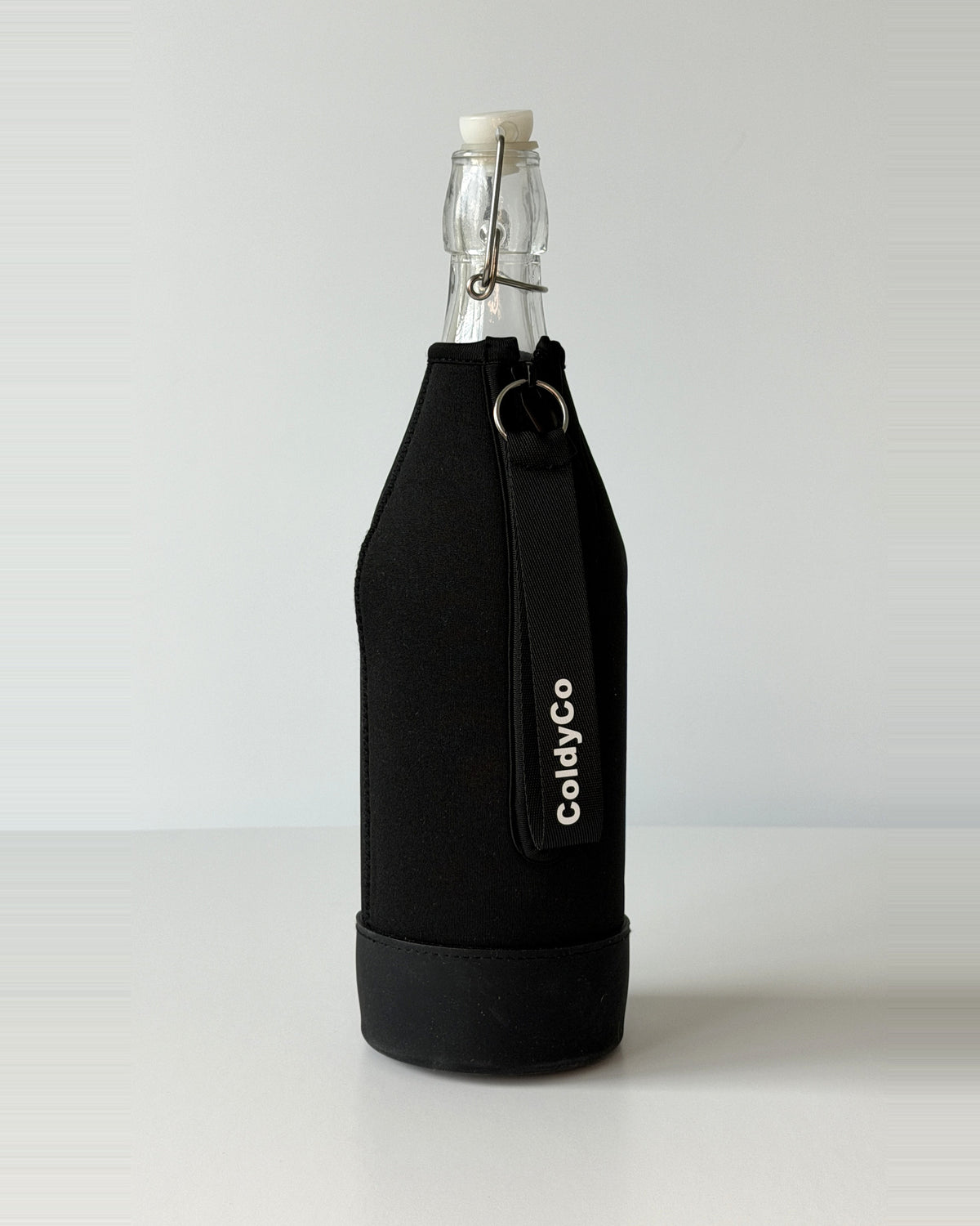 ColdyCo Black bottle carrier holding a swing-top glass bottle, side view