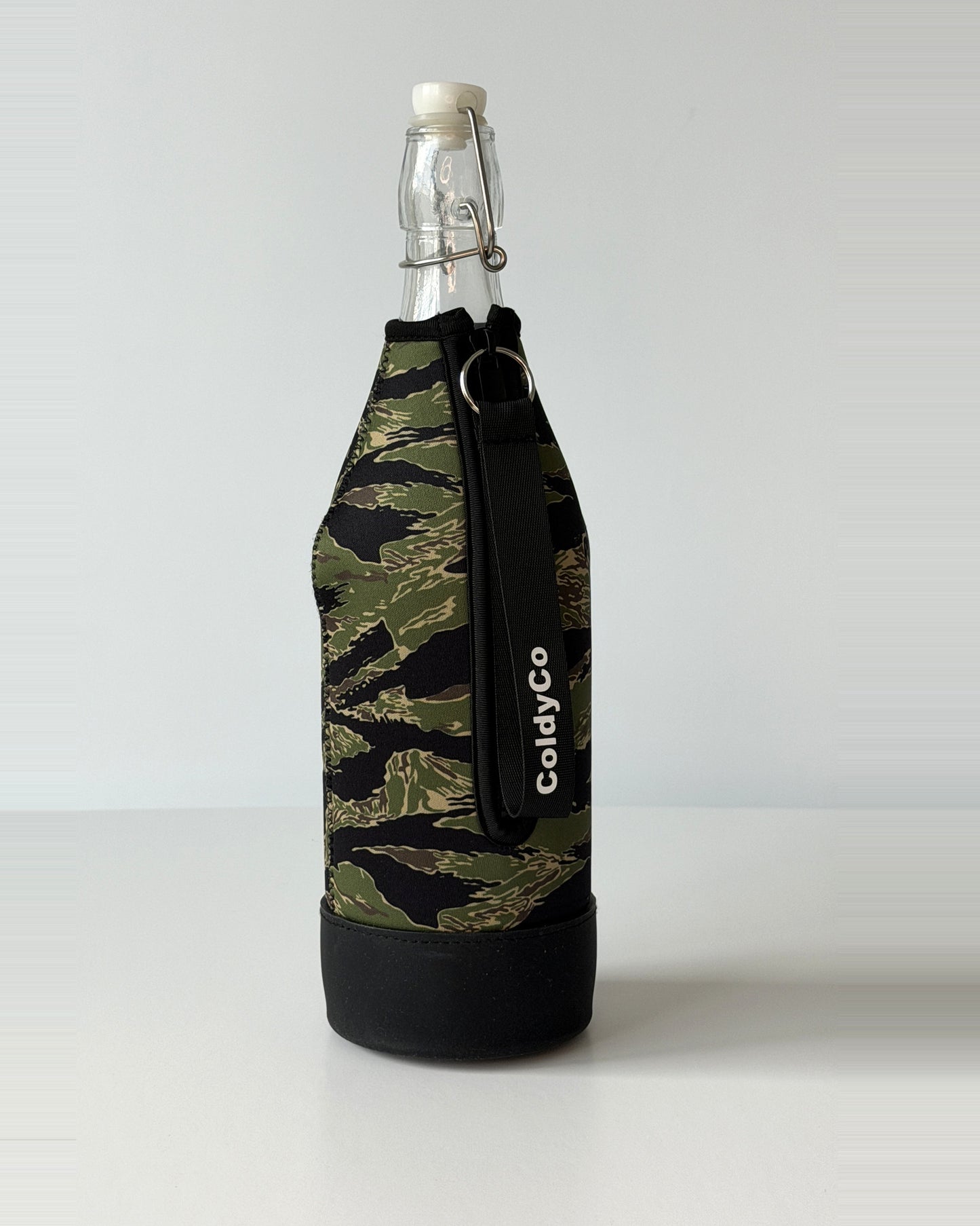 ColdyCo Camo bottle carrier holding a swing-top glass bottle, side view