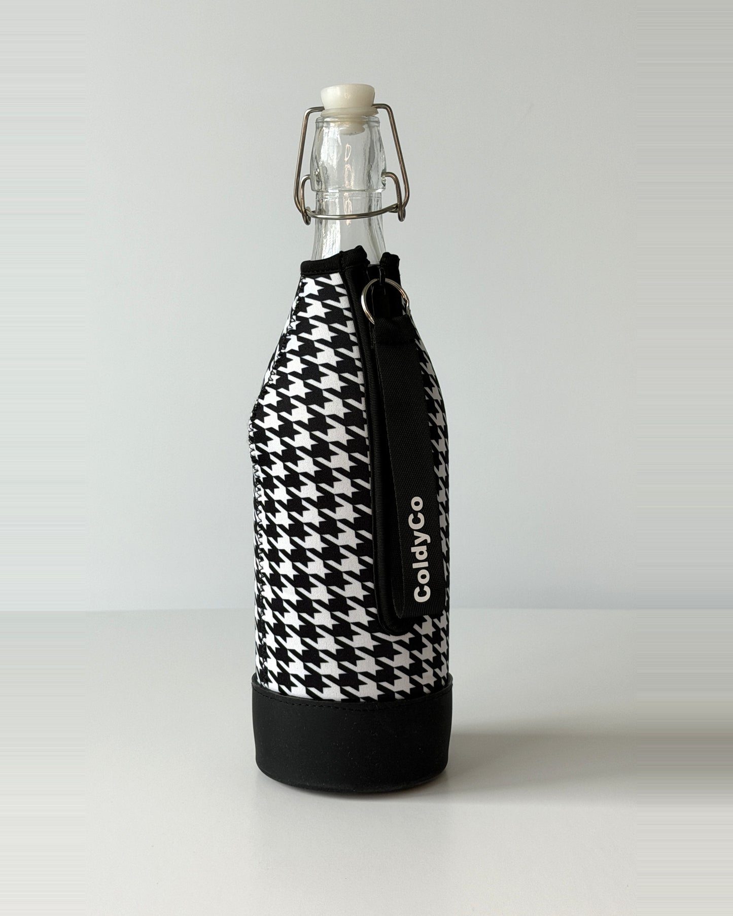 ColdyCo Houndstooth bottle carrier holding a swing-top glass bottle, side view