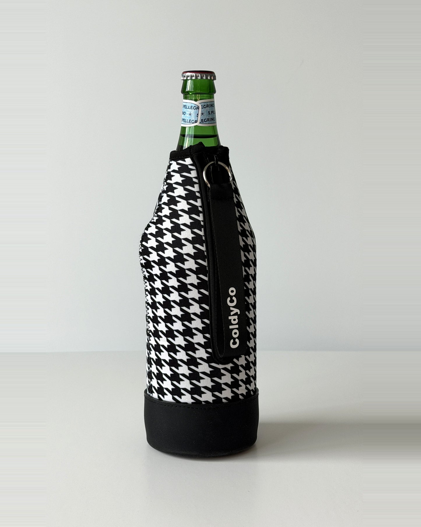 ColdyCo Houndstooth neoprene sleeve with wrist strap on a 1-liter glass bottle