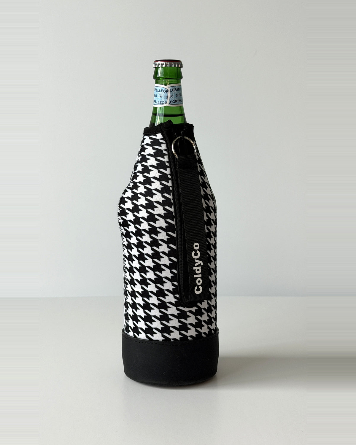 ColdyCo Houndstooth neoprene sleeve with wrist strap on a 1-liter glass bottle