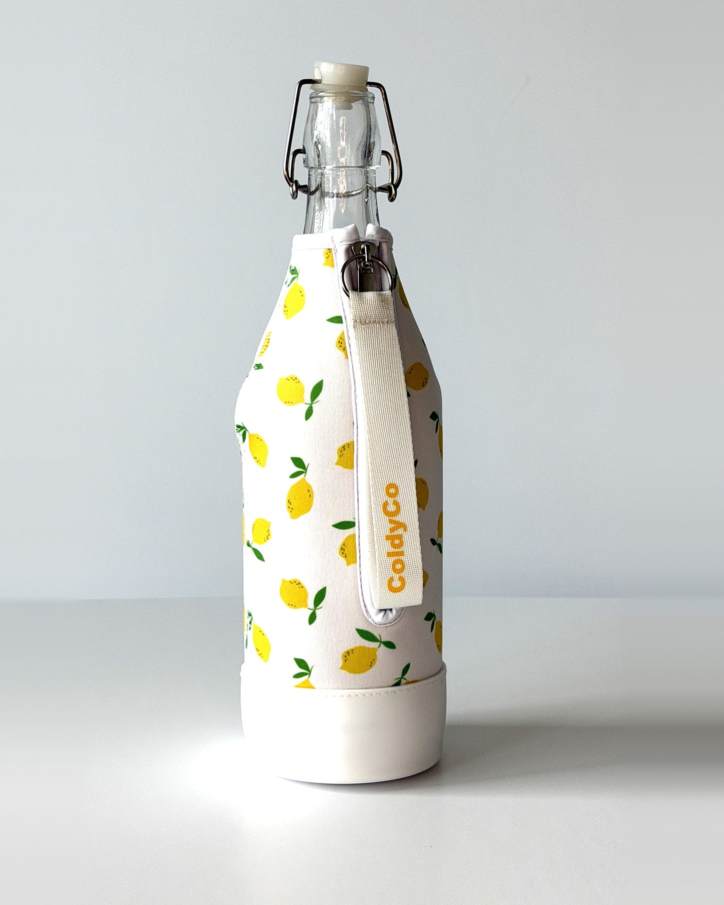 ColdyCo Lemon Print bottle carrier holding a swing-top glass bottle, side view