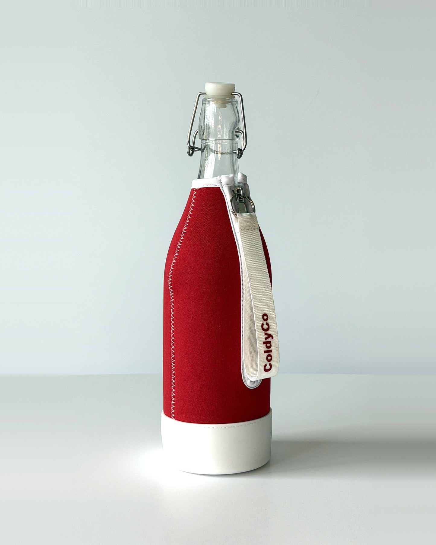 ColdyCo Red and White bottle carrier holding a swing-top glass bottle, side view