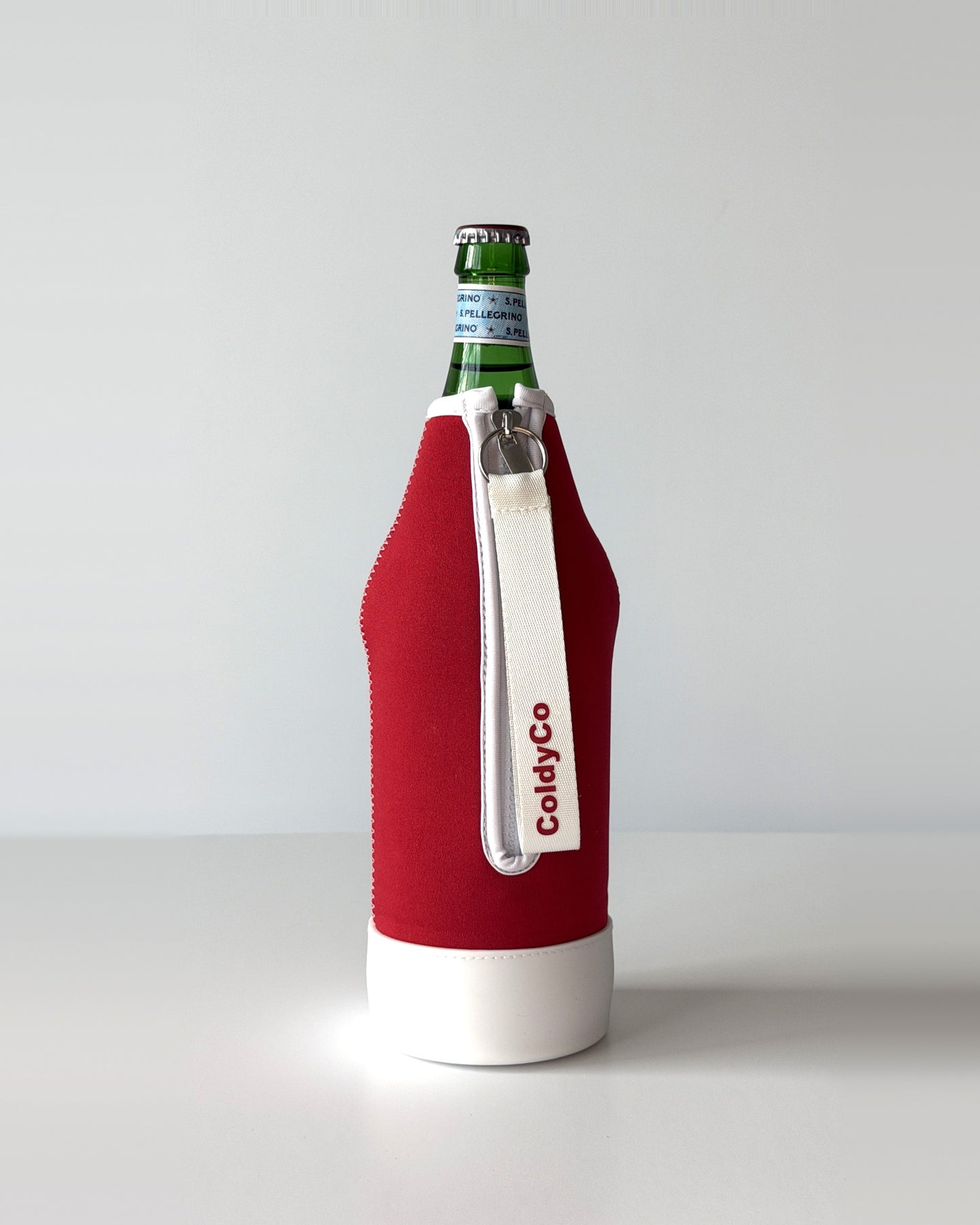 ColdyCo Red and White neoprene sleeve with wrist strap on a 1-liter glass bottle