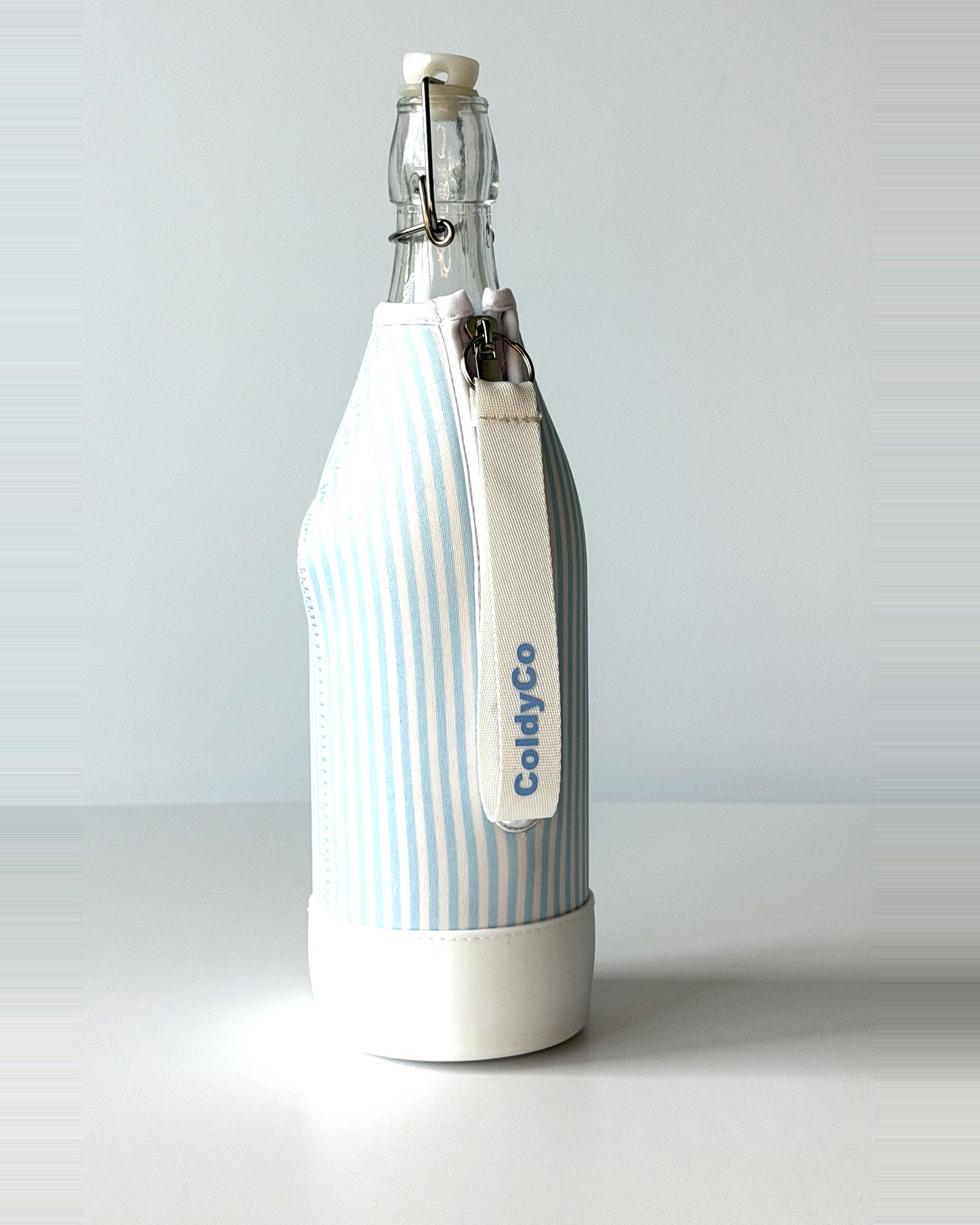 ColdyCo Sky Blue Stripe bottle carrier holding a swing-top glass bottle, side view