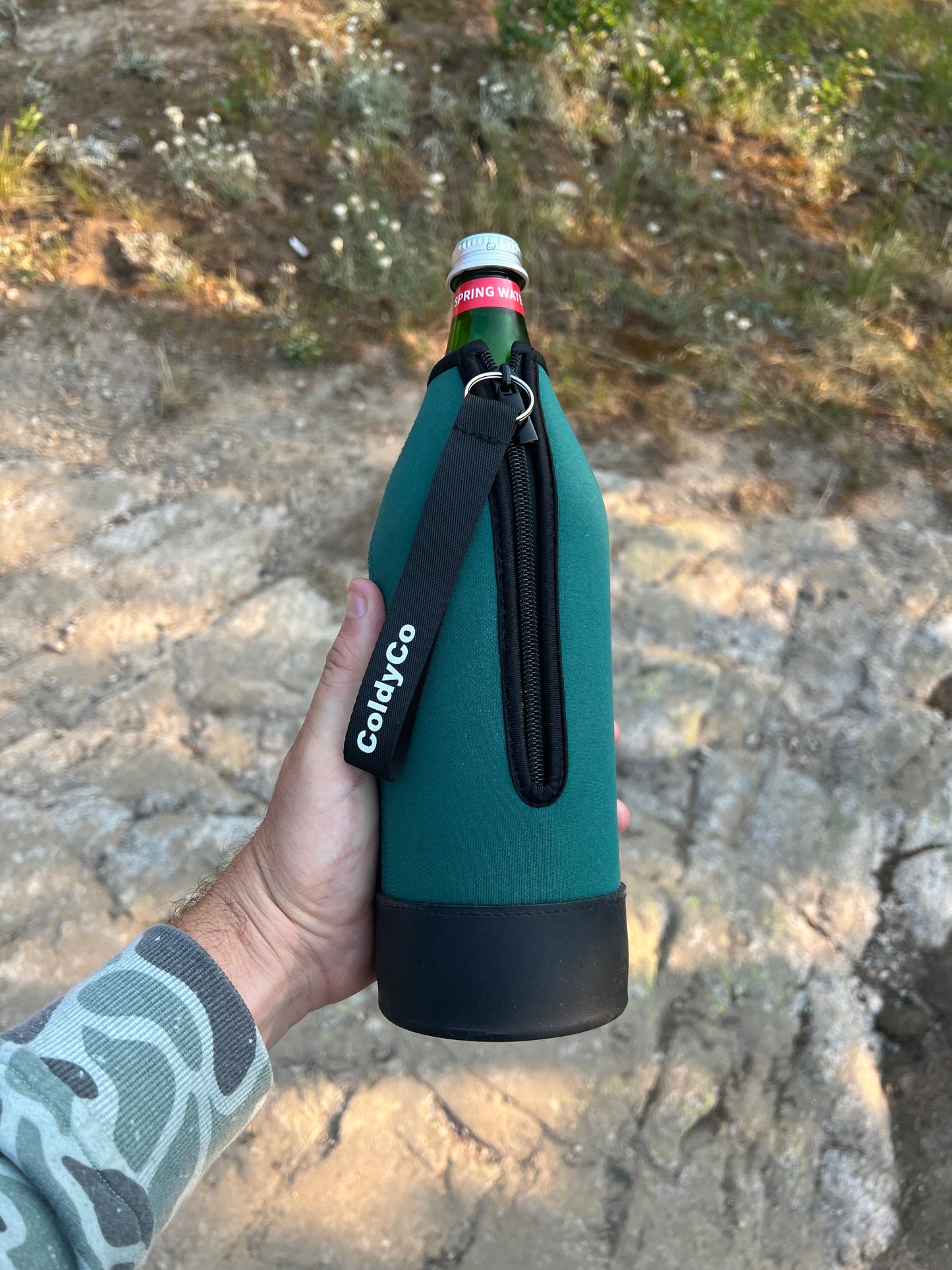 Person using ColdyCo neoprene bottle sleeve for outdoor activities
